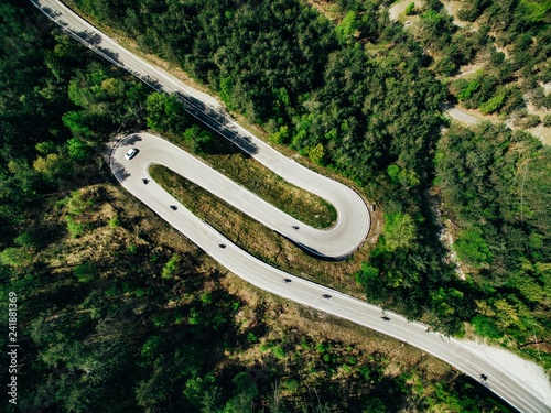 Aerial above view of a rural mountain landscape with a curvy road in Italy.