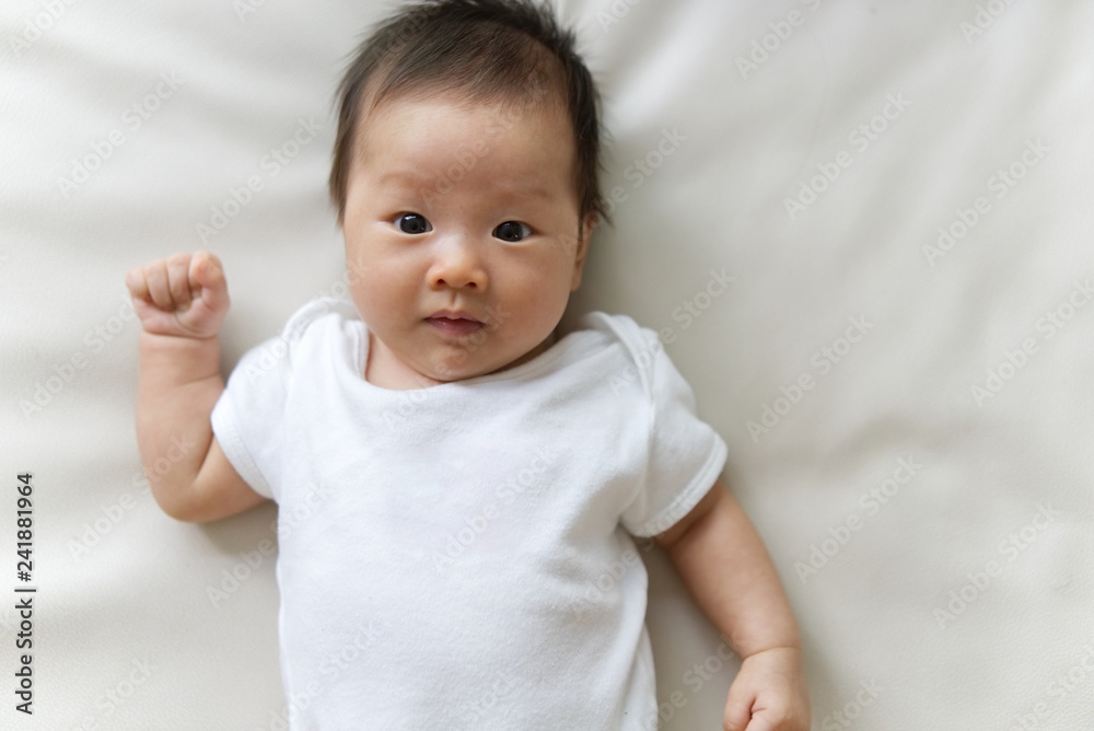 Asian newborn baby wearing white T-shirt lying on white sofa. Seen from top  and close up at baby face. Cute Asian baby model concept. Stock Photo |  Adobe Stock