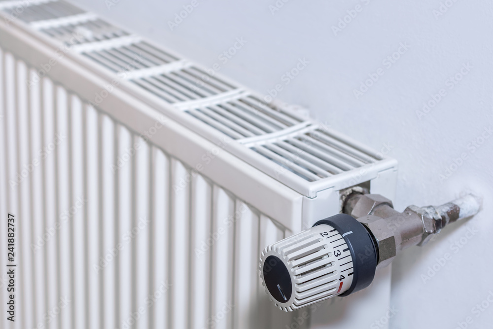 Heizkörper an einer Wand mit Thermostat Heizkörper an einer Wand mit Thermostat