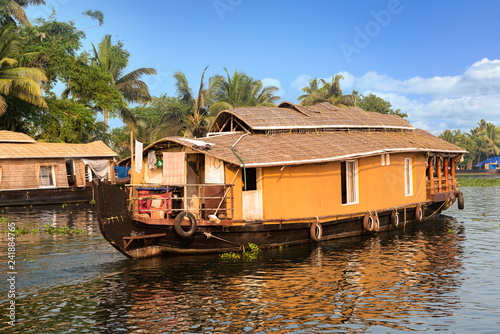 A traditional house boat is anchored on the shores of a fishing lake in Kerala's Backwaters, India. - Image
