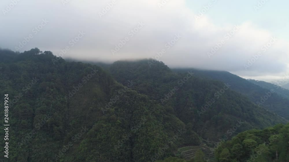 Aerial view mountains covered forest, trees against the sky and clouds. Cordillera region. Luzon, Philippines. Mountainous tropical landscape. Aerial view mountains covered forest, trees against the sky and clouds. Cordillera region. Luzon, Philippines. Mountainous tropical landscape.