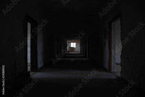 Dark corridor of abandoned decay building with few light, urbex 