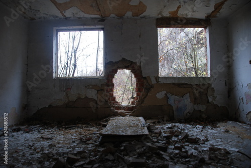 Fotografie Urbex, scary abandoned and dark room with two windows and broken brick wall