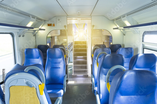 Salon inside of the speed commuter train with empty seats staircase to the second floor.