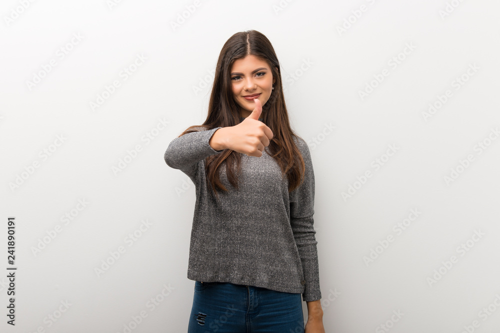 Teenager girl on isolated white backgorund giving a thumbs up gesture because something good has happened Teenager girl on isolated white backgorund giving a thumbs up gesture because something good has happened