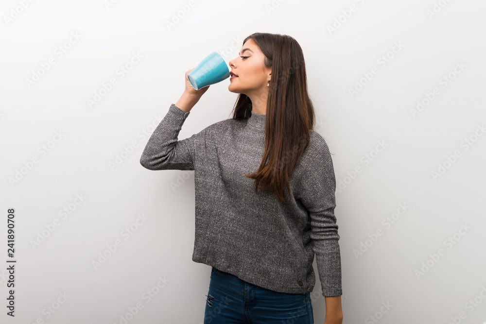 Teenager girl on isolated white backgorund holding a hot cup of coffee Teenager girl on isolated white backgorund holding a hot cup of coffee
