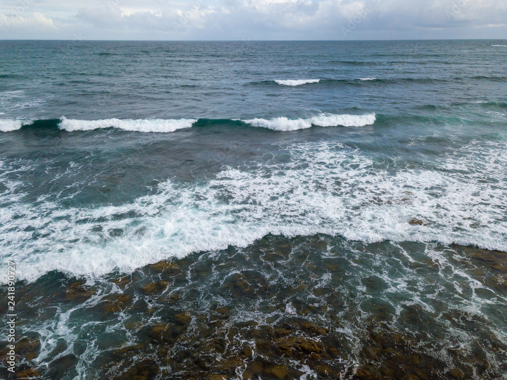 Fototapeta premium Aerial view of ocean waves and rocky coast in South Africa
