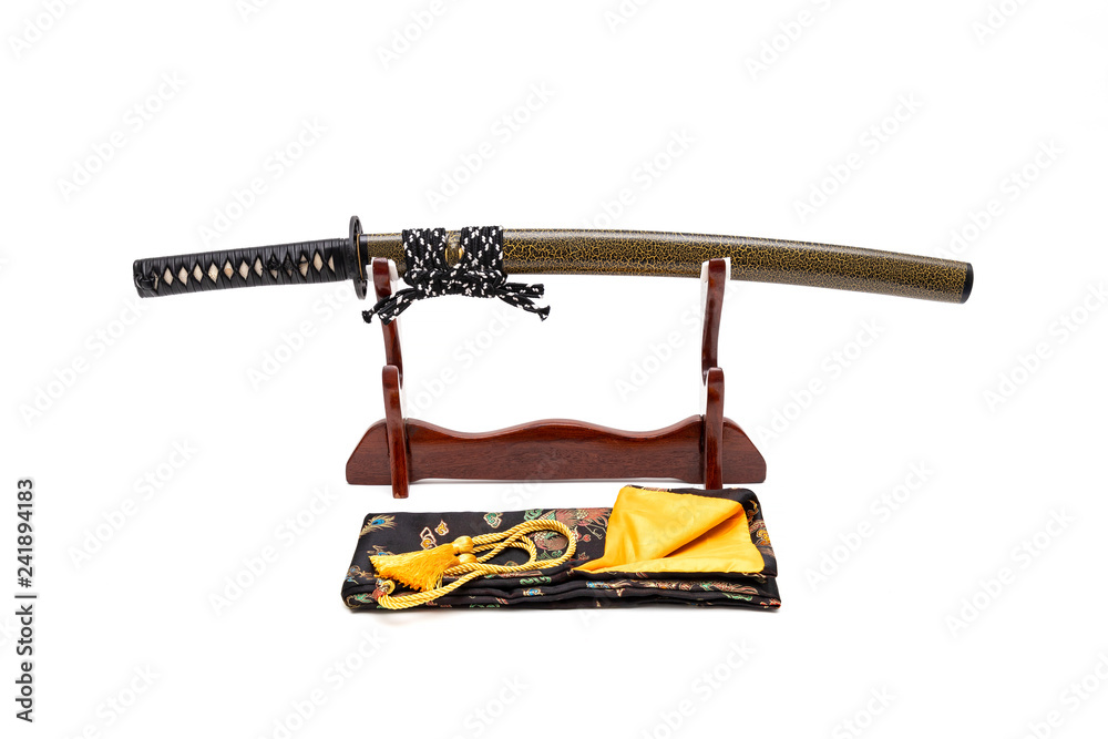 Black handle Japanese sword with green textured scabbard on stand with white background, Black silk bag in front of the stand.