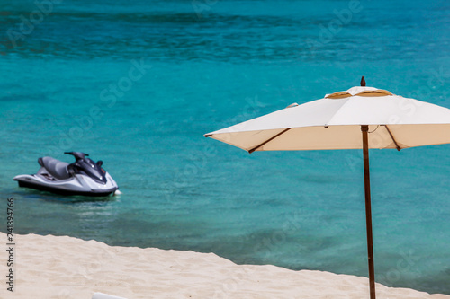 Fototapeta Naklejka Na Ścianę i Meble -  Umbrella with jet ski, beach sand and ocean
