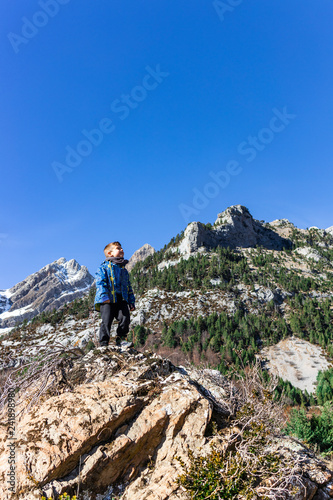 Little mountaineer on the peak of the mountains