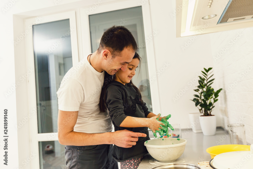 Father and daughter making meal together in kitchen. Cooking classes concept Father and daughter making meal together in kitchen. Cooking classes concept