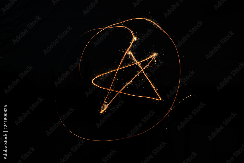The sign of the star in the circle of sparklers