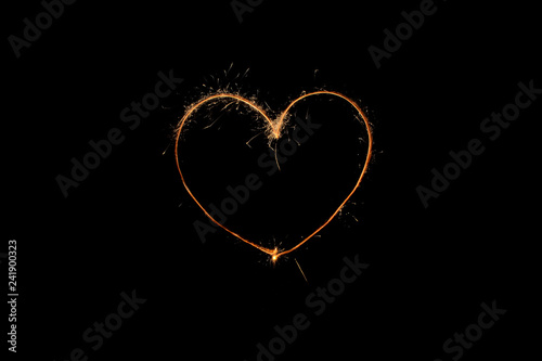 The sign of the heart in the circle of sparklers