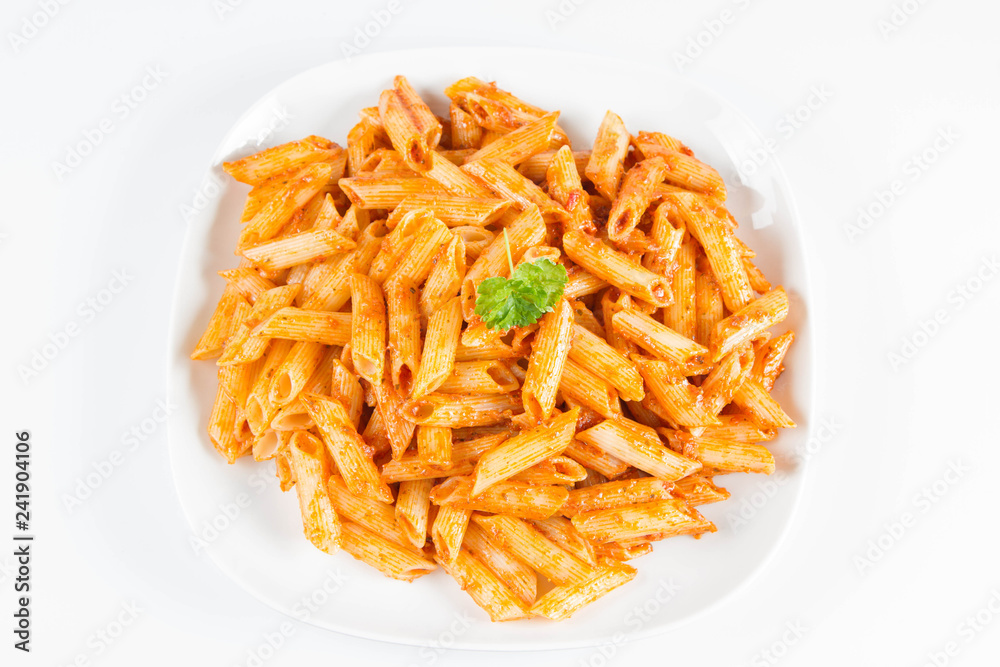 Penne with pesto decorated with parsley on a plate on a white background Penne with pesto decorated with parsley on a plate on a white background