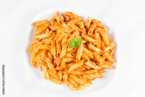 Penne with pesto decorated with parsley on a plate on a white background