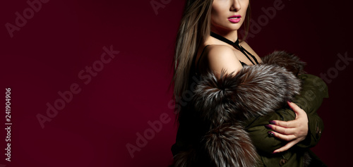Young sexy fashion woman in fur coat and underwear on dark red. Banner