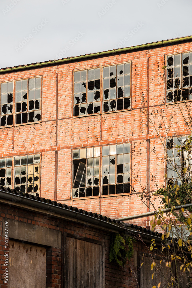 Fototapeta premium Old destroyed brick house ruin with broken windows