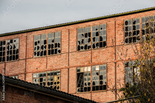 Old destroyed brick house ruin with broken windows