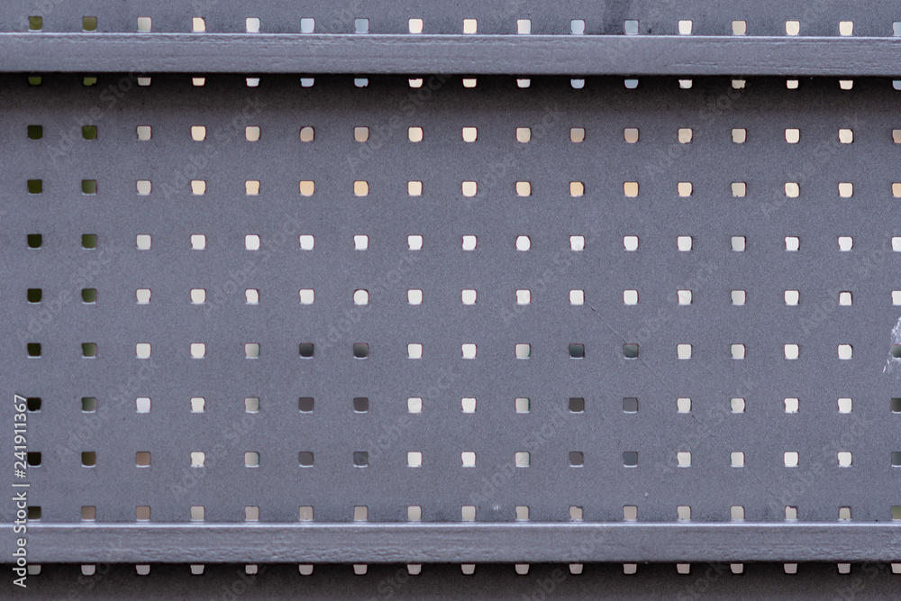 Part of a metal gate with square holes.