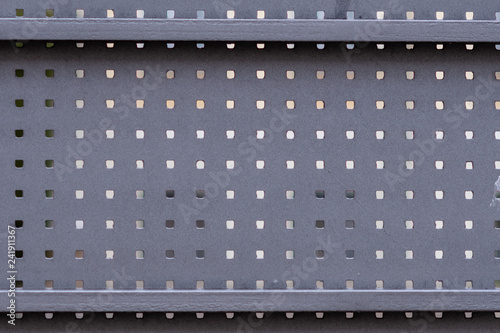 Part of a metal gate with square holes.