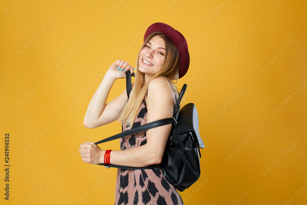 Happy tourist woman holding travel yellow case and credit card. Studio portrait. Vacation concept. Happy tourist woman holding travel yellow case and credit card. Studio portrait. Vacation concept.
