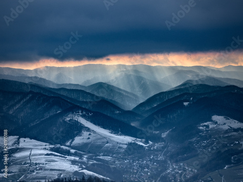 Sunset in cloudy weather in Beskids Mountains in winter. Near Rytro Village, view from Mount Makowica. © ffolas