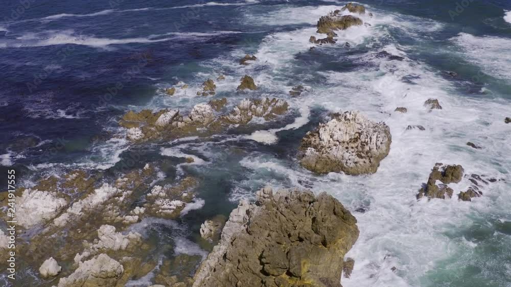 fly over rocks with waves crashing over them fly over rocks with waves crashing over them