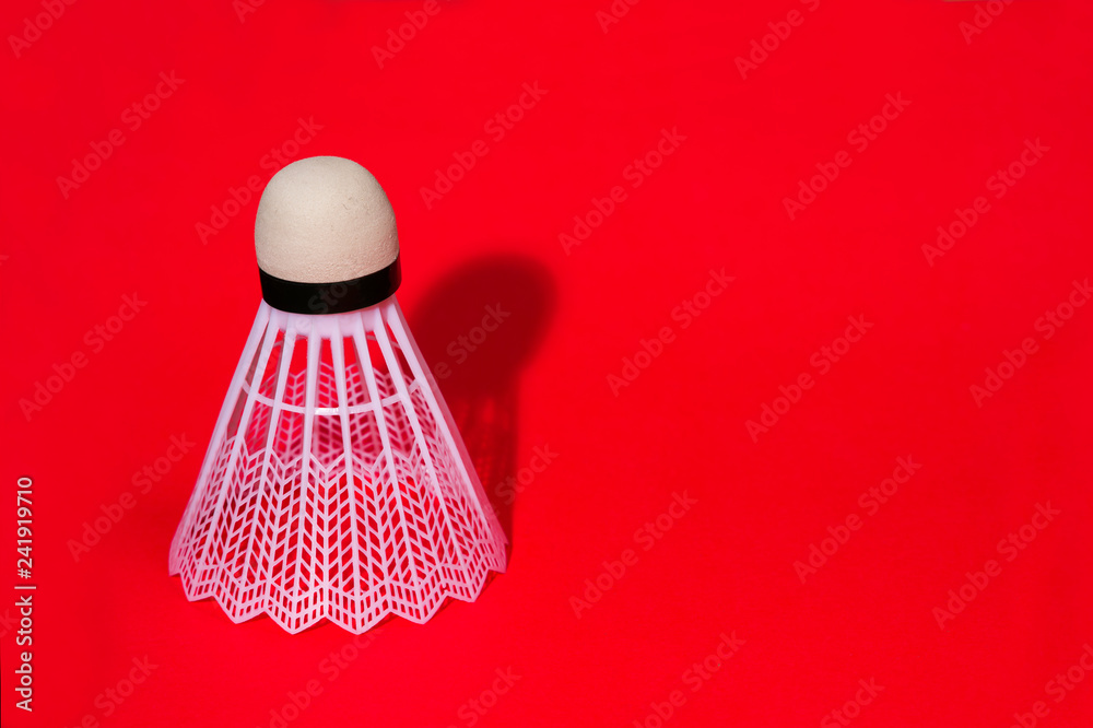 Shuttlecock in the lower right corner, on red background. copy space