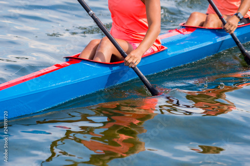 Fotografi Two young woman athletes on rowing kayak on lake during competition