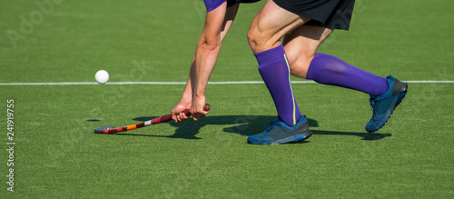 Field Hockey player, forcefully passing the ball