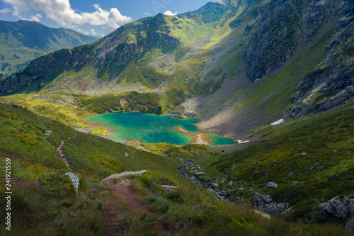 Small lake in the mountains of Arkhyz. The beautiful summer landscape with mountain of Caucasus and lake with blue water. Mountain lake scenery landscape.