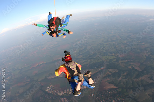 Professional parachutist taking photos of a tandem jump