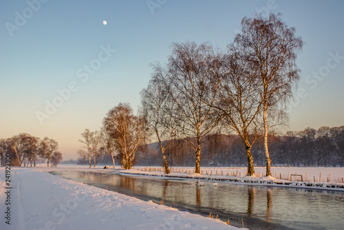 Mond über Fluss am klaren Himmel. Sonnenuntergang und wunderbare Schneelandschaft © Marc