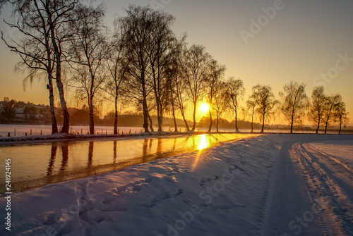 Goldene Stunde. Goldiger Sonnenuntergang über Fluss. Schnee Winter Wonderland. Wunderbare Schneelandschaft © Marc