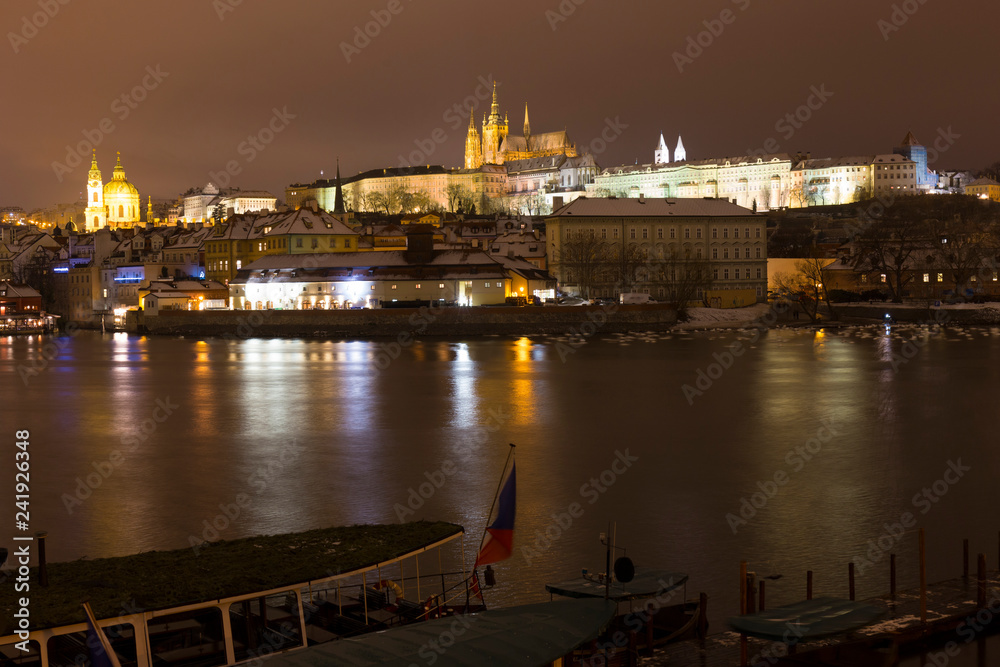 Night snowy Christmas Prague Lesser Town with gothic Castle above River Vltava, Czech republic