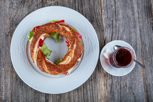 Turkish Bagel Simit Sandwich with cheese, tomato, cucumber and tea. photo