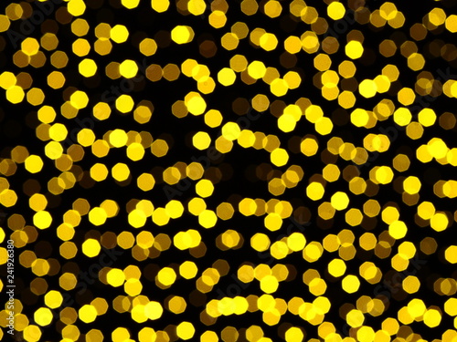 Gold christmas lights in night. Sparkling festive background of golden Christmas lights ob black background