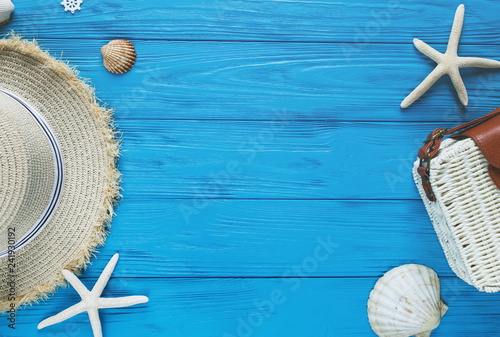 White rattan bag, straw hat on blue background. bamboo trendy bag, starfish, shells. Summer fashion flat lay,   vacation, travel concept. photo