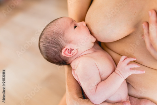Young woman breastfeeding a baby newborn. photo
