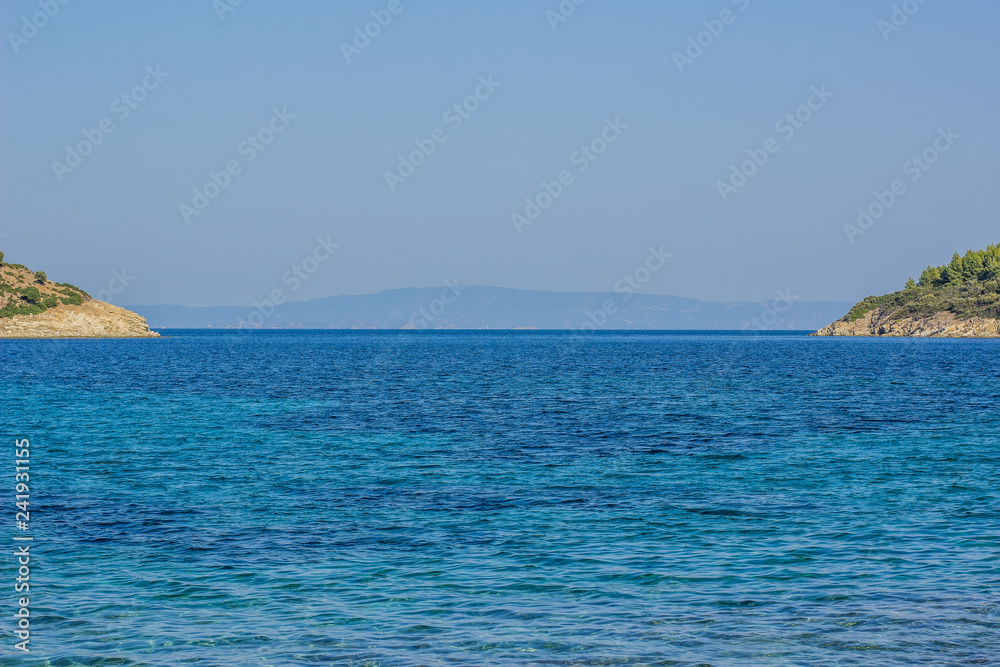 Fototapeta premium picturesque symmetry tropic scenic landscape with islands coast on both sides of photography and vivid blue water surface of sea bay on foreground, summer vacation and tourist agency concept