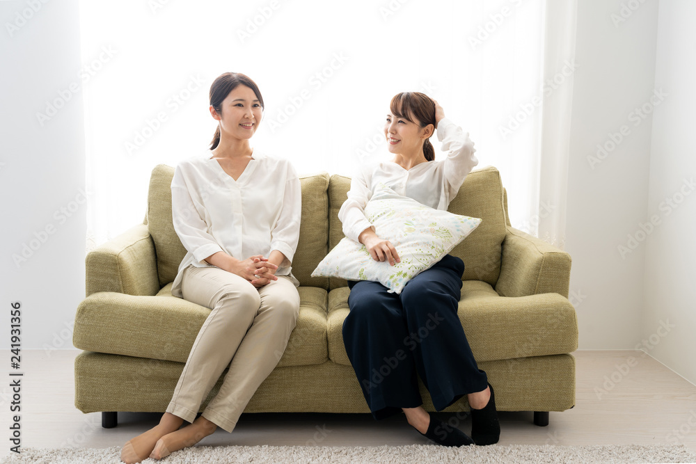 two young asian women relaxing in living room two young asian women relaxing in living room