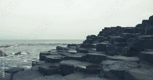 hand hold shoot view of walking on the giant causeway hexagon stone and move forward 