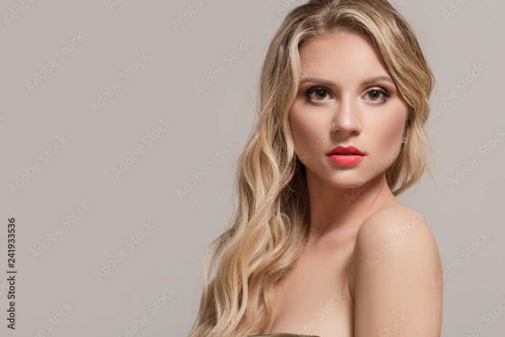 Fashion woman blond with long wavy hair. Woman with beautiful makeup and red lipstick Fashion woman blond with long wavy hair. Woman with beautiful makeup and red lipstick