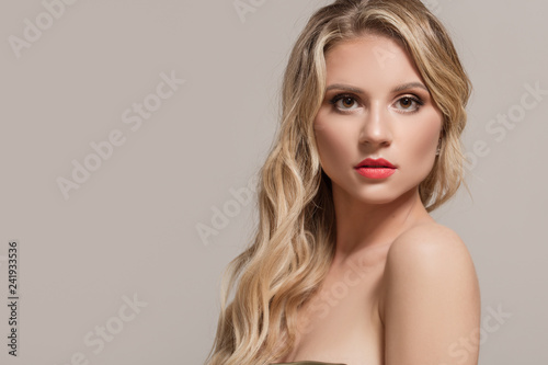Fashion woman blond with long wavy hair. Woman with beautiful makeup and red lipstick