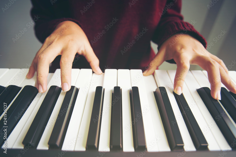 Close up woman hand playing piano.