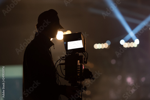 closeup Video Cameraman taking Concert crowd in silhouettes of Music fanclub with show hand action which follow up the songer at the front of stage with follow light, musical and concert concept