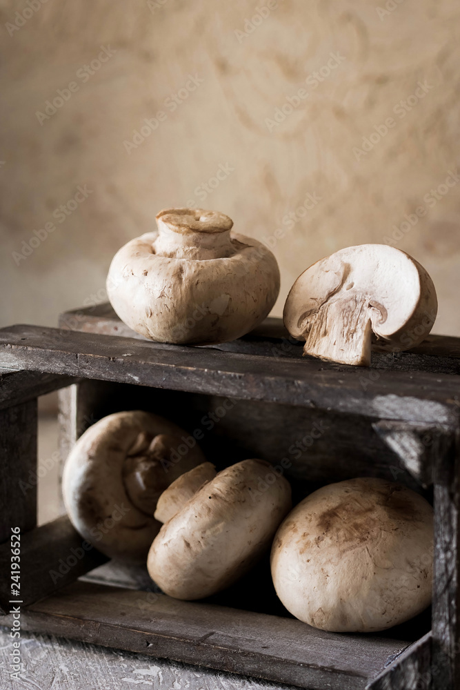Raw champignons on a rustic wooden box Raw champignons on a rustic wooden box