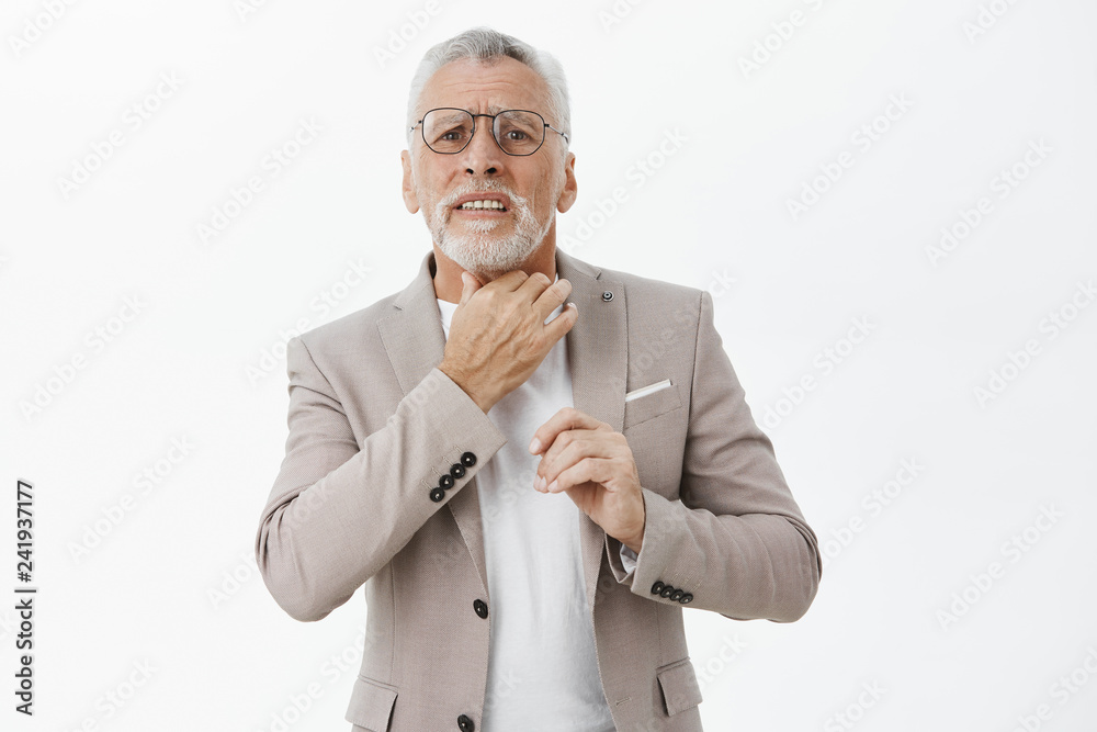 Waist-up shot of concerned and troubled insecure old male entrepreneur in glasses and suit with white hair feeling sick touching neck suffering from sore throat complaining of painful discomfort Stock Photo | Waist-up shot of concerned and troubled insecure old male entrepreneur in glasses and suit with white hair feeling sick touching neck suffering from sore throat complaining of painful discomfort Stock Photo |
