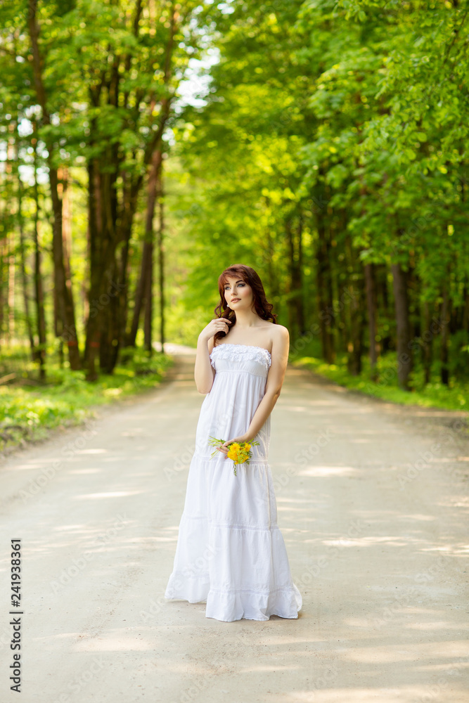 beautiful girl with dandelion flowers on forest road beautiful girl with dandelion flowers on forest road