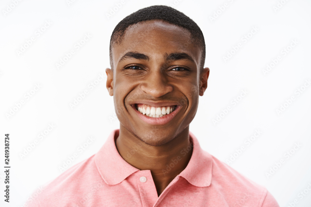Headshot of happy successful and delighted young african american male student smiling broadly with joy and delight showing perfect white teeth, enjoying life, feeling uplifted and satisfied Headshot of happy successful and delighted young african american male student smiling broadly with joy and delight showing perfect white teeth, enjoying life, feeling uplifted and satisfied